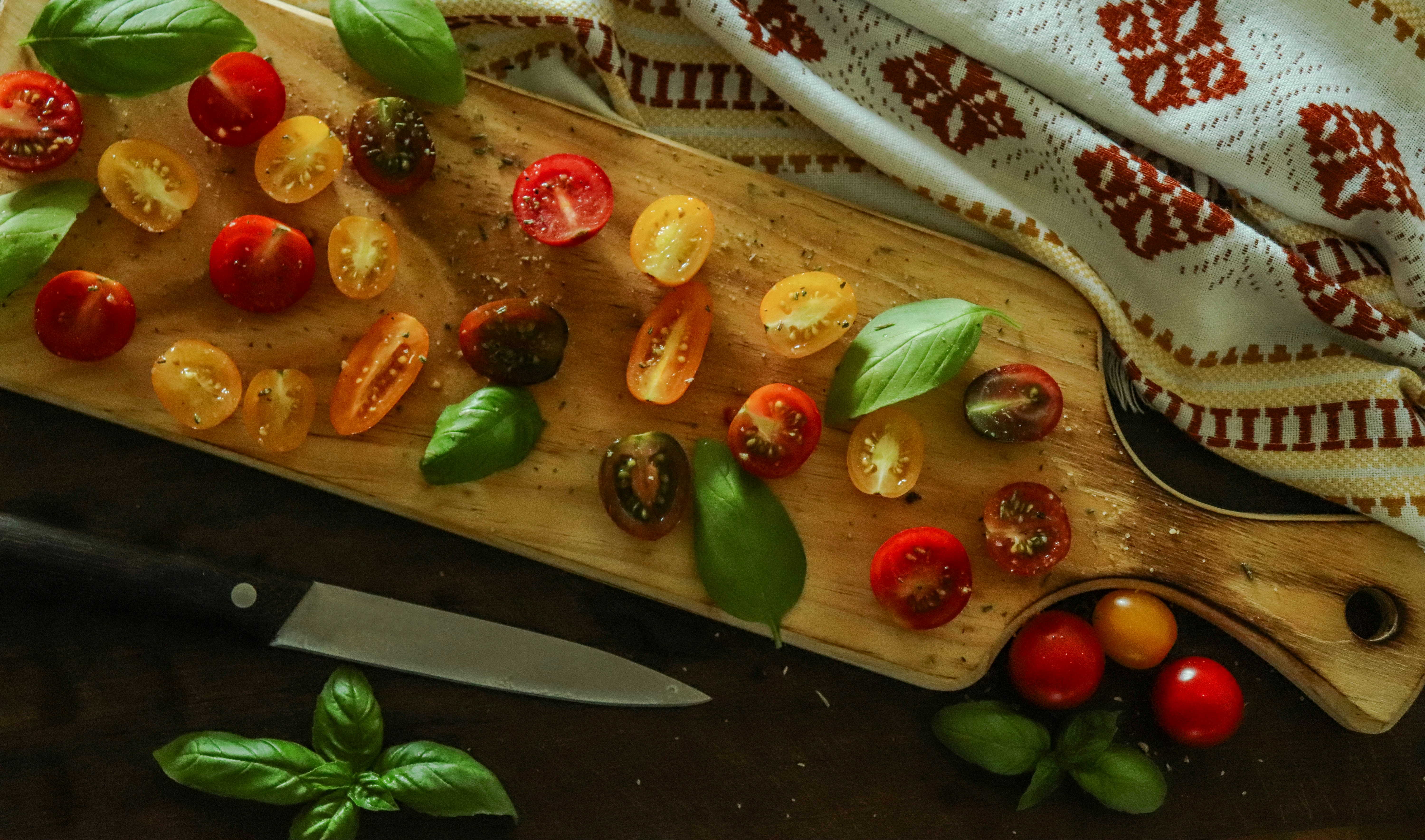 Cut red and yellow cherry tomatoes on a board