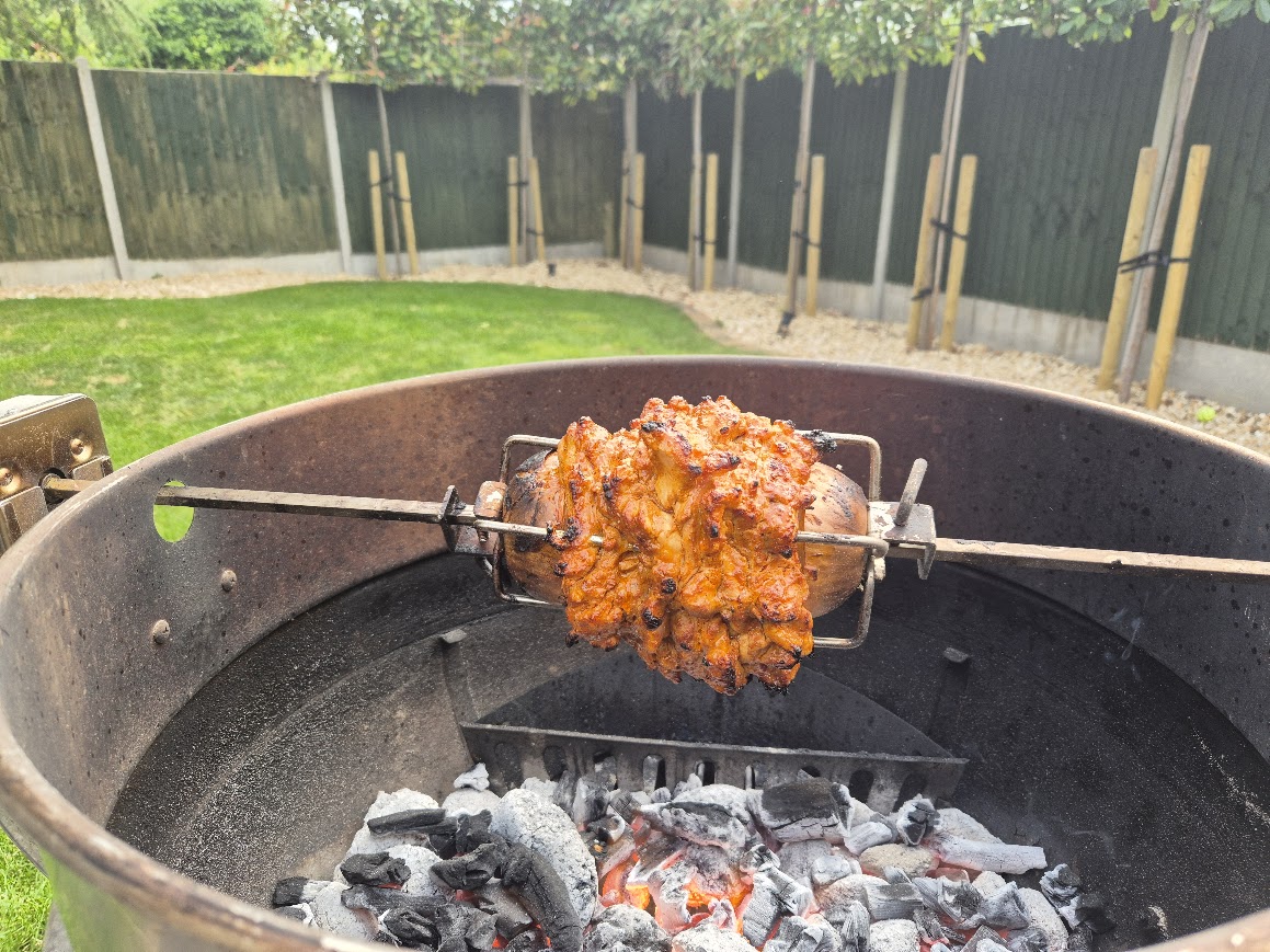 Homemade chicken donner kebab cooked on a rotisserie over coal